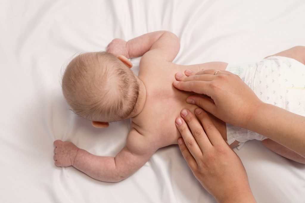 baby massage, close up hands on baby back