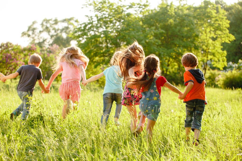 A group of happy children of boys and girls run in the Park on t