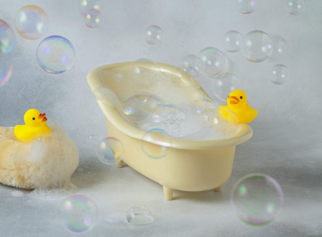 bath with soapy foam, bubbles and yellow rubber ducks