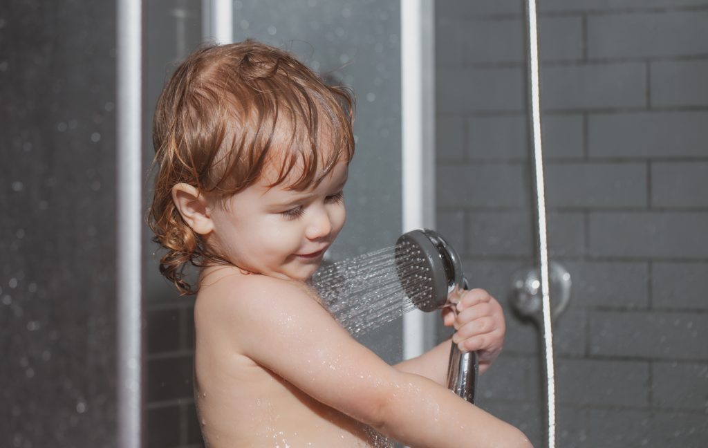 Kid having fun to bath. Cute baby boy enjoying bath and bathed in the bathroom.